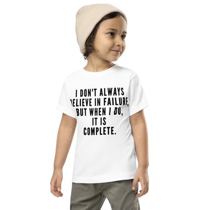"I don't always believe in failure, but when I do, it is complete." printed on a white toddler short sleeve tee worn by a male wearing a cap