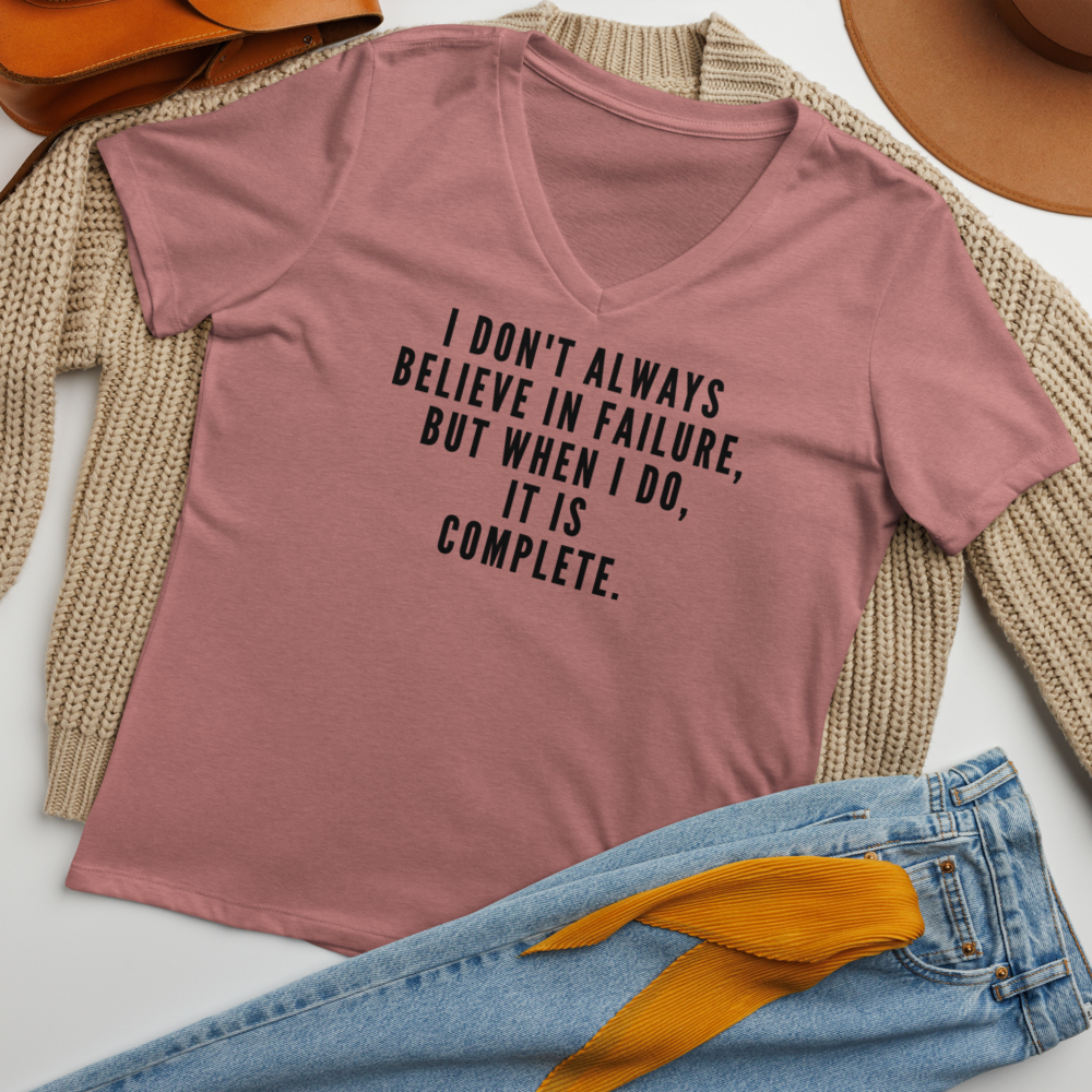 "I don't always believe in failure, but when I do, it is complete." printed on a heather mauve women's relaxed v-neck t-shirt laying on a flat surface amongst other clothes