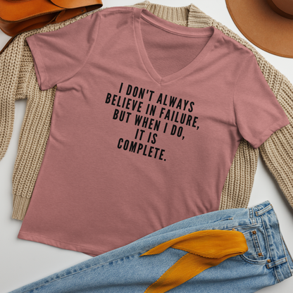 "I don't always believe in failure, but when I do, it is complete." printed on a heather mauve women's relaxed v-neck t-shirt laying on a flat surface amongst other clothes