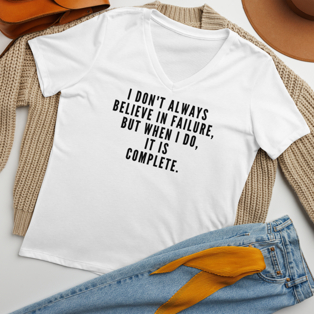 "I don't always believe in failure, but when I do, it is complete." printed on a solid white blend women's relaxed v-neck t-shirt laying on a flat surface amongst other clothes