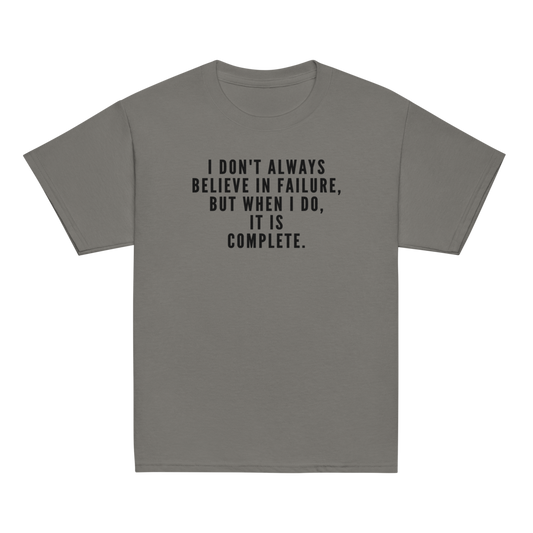"I don't always believe in failure, but when I do, it is complete." printed on a charcoal youth classic tee laying on a flat surface