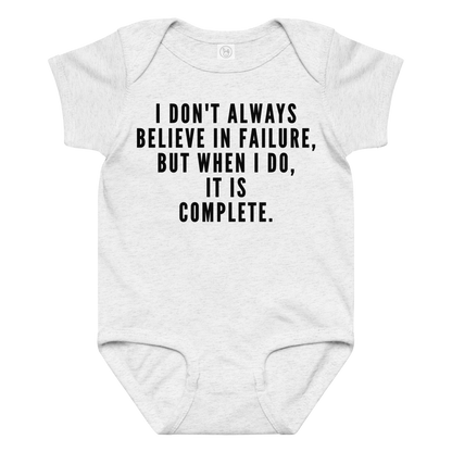 "I don't always believe in failure, but when I do, it is complete." printed on a ash baby jersey bodysuit laying on a flat surface amongst other clothes