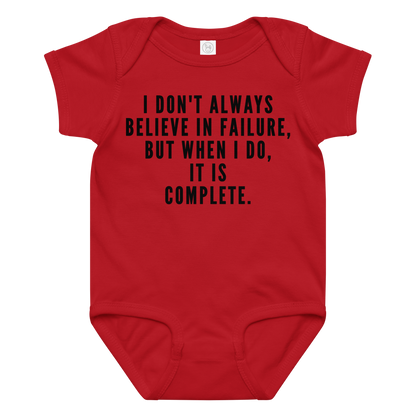 "I don't always believe in failure, but when I do, it is complete." printed on a red baby jersey bodysuit laying on a flat surface amongst other clothes