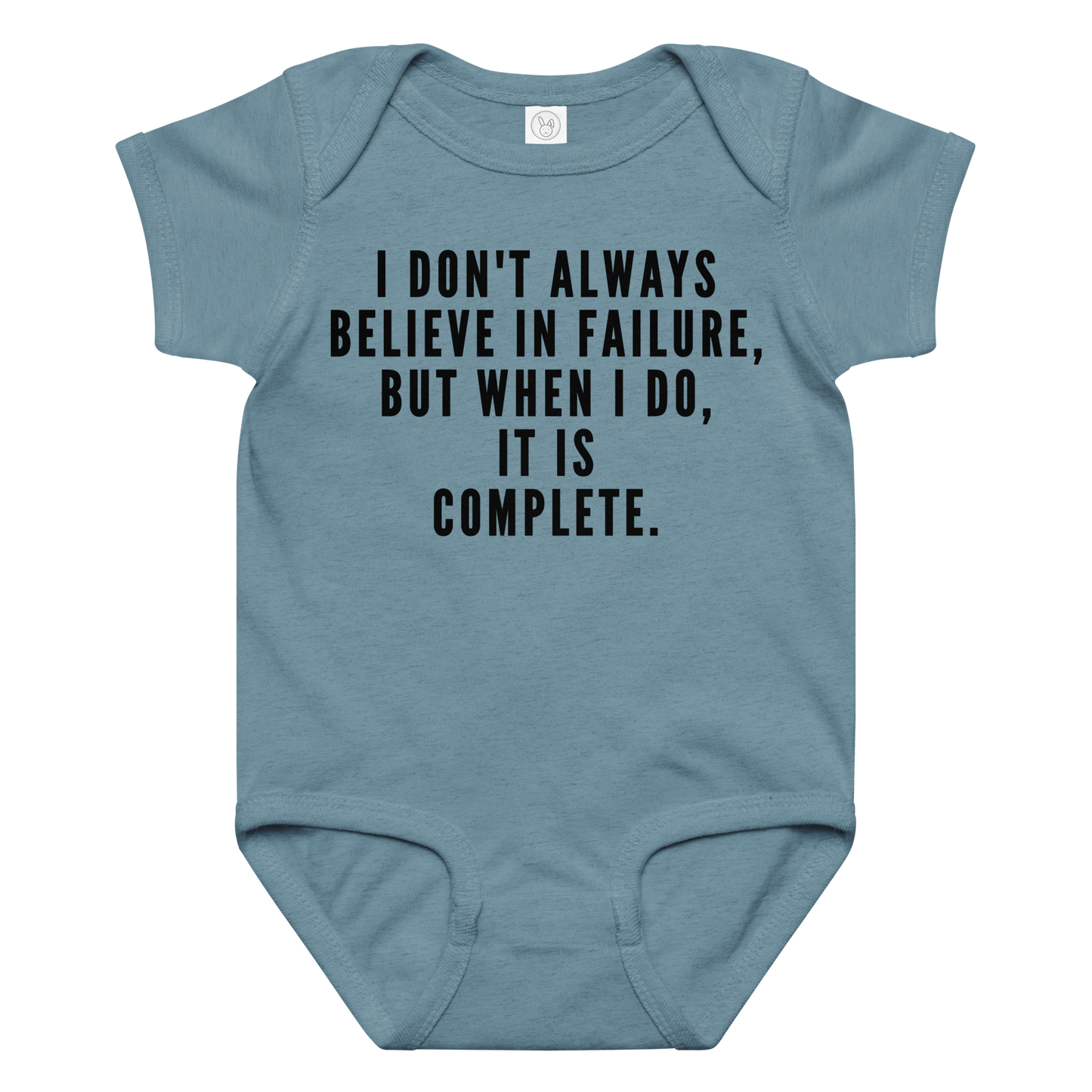 "I don't always believe in failure, but when I do, it is complete." printed on a vintage indigo baby jersey bodysuit laying on a flat surface amongst other clothes