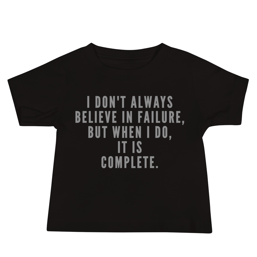 "I don't always believe in failure, but when I do, it is complete." printed on a black baby jersey short sleeve tee laying on a flat surface