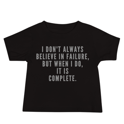 "I don't always believe in failure, but when I do, it is complete." printed on a black baby jersey short sleeve tee laying on a flat surface