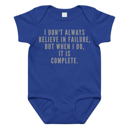 "I don't always believe in failure, but when I do, it is complete." printed on a royal baby jersey bodysuit laying on a flat surface amongst other clothes