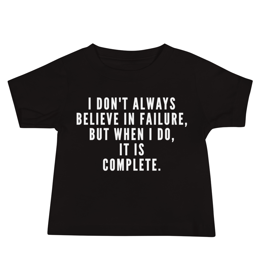 "I don't always believe in failure, but when I do, it is complete." printed on a black baby jersey short sleeve tee laying on a flat surface
