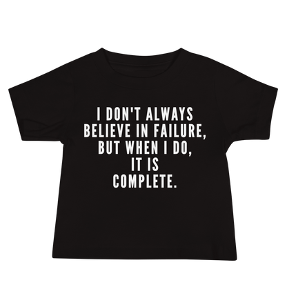 "I don't always believe in failure, but when I do, it is complete." printed on a black baby jersey short sleeve tee laying on a flat surface