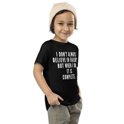 "I don't always believe in failure, but when I do, it is complete." printed on a black toddler short sleeve tee worn by a male who is also wearing a knit cap