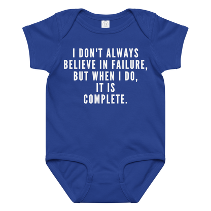 "I don't always believe in failure, but when I do, it is complete." printed on a royal baby jersey bodysuit laying on a flat surface amongst other clothes