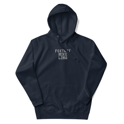 "Foxtrot Mike Lima" printed on a navy blazer unisex hoodie laying on a flat surface with the hood up
