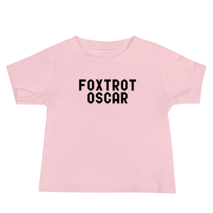 "Foxtrot Oscar" printed on a pink baby jersey short sleeve tee laying on a flat surface