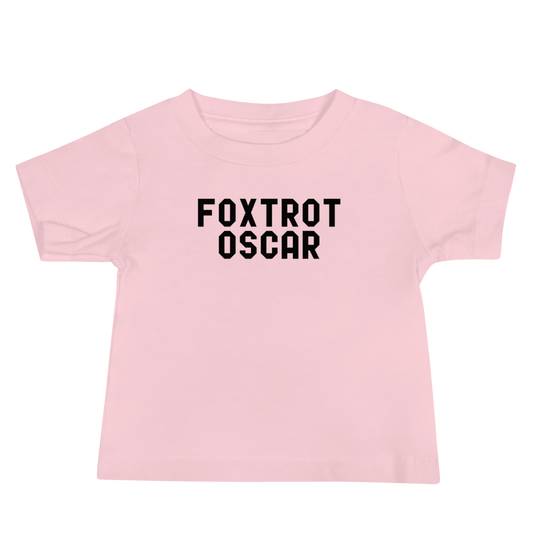 "Foxtrot Oscar" printed on a pink baby jersey short sleeve tee laying on a flat surface