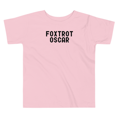 "Foxtrot Oscar" printed on a pink toddler short sleeve tee laying on a flat surface