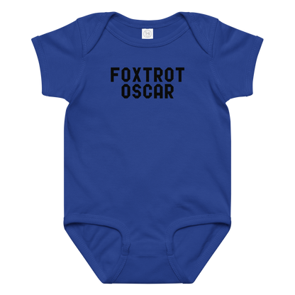 "Foxtrot Oscar" printed on a royal baby jersey bodysuit laying on a flat surface amongst other clothes