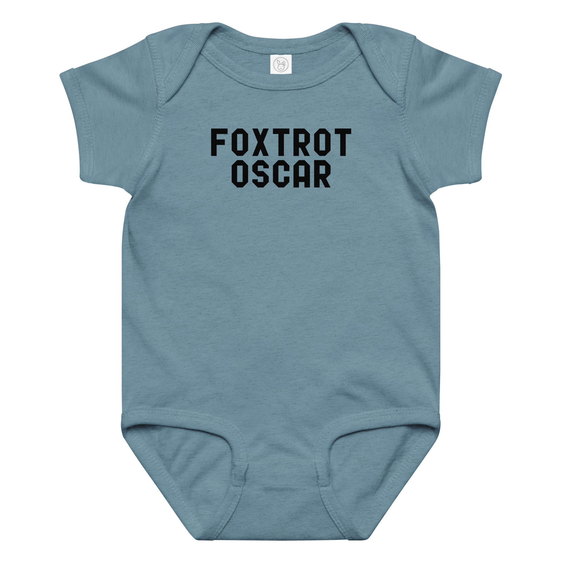 "Foxtrot Oscar" printed on a vintage indigo baby jersey bodysuit laying on a flat surface amongst other clothes