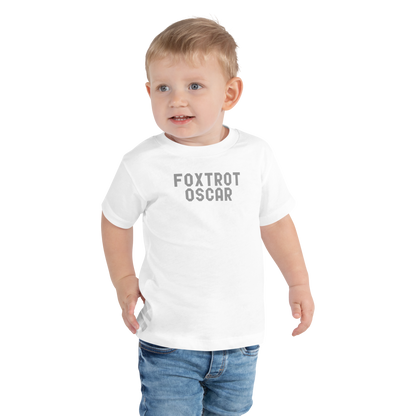 "Foxtrot Oscar" printed on a white toddler short sleeve tee worn by a male