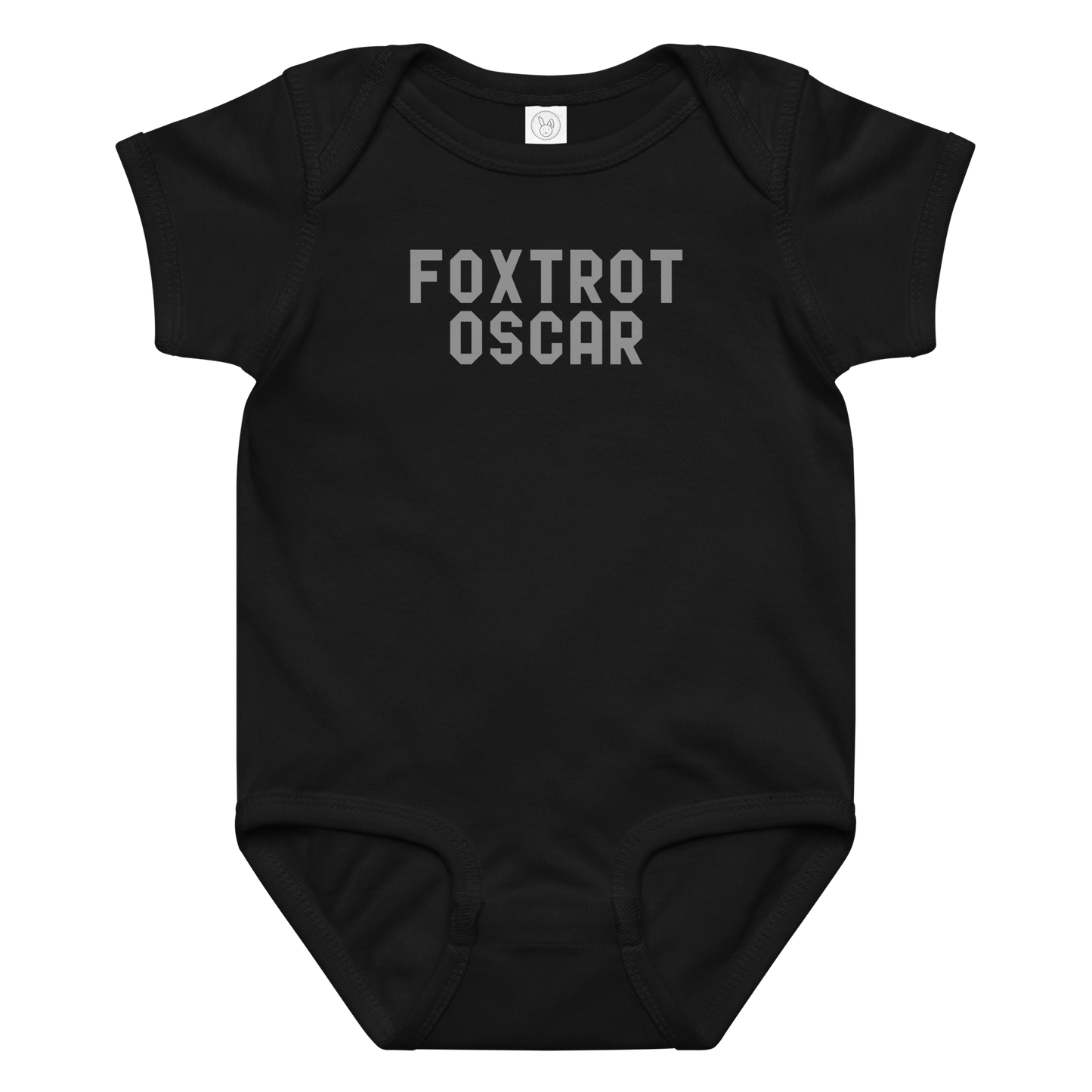 "Foxtrot Oscar" printed on a black baby jersey bodysuit laying on a flat surface amongst other clothes