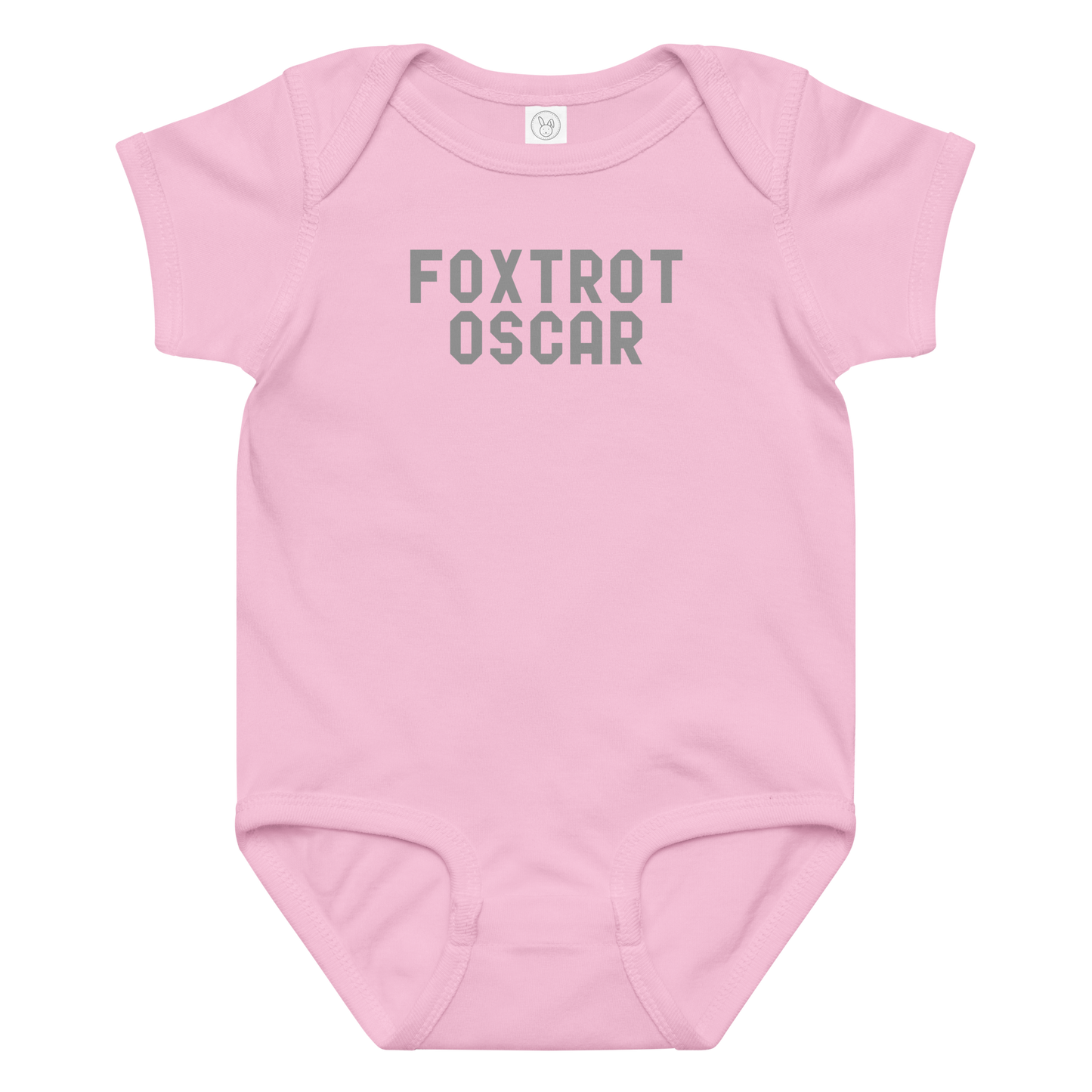 "Foxtrot Oscar" printed on a pink baby jersey bodysuit laying on a flat surface amongst other clothes