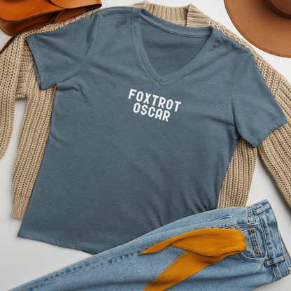 "Foxtrot Oscar" printed on a heather slate women's relaxed v-neck t-shirt laying on a flat surface amongst other clothes