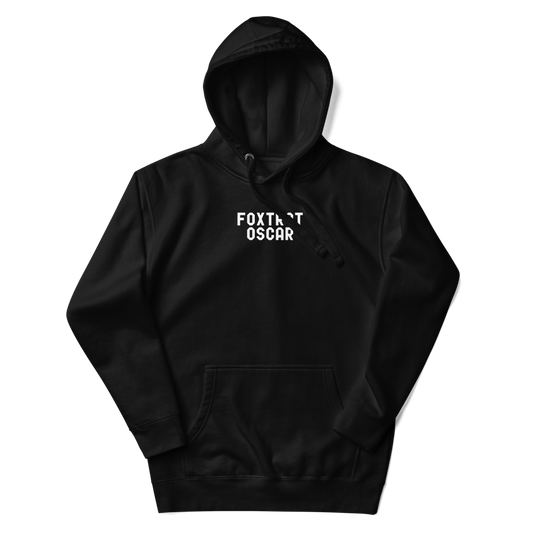 "Foxtrot Oscar" printed on a black unisex hoodie laying on a flat surface with the hood up