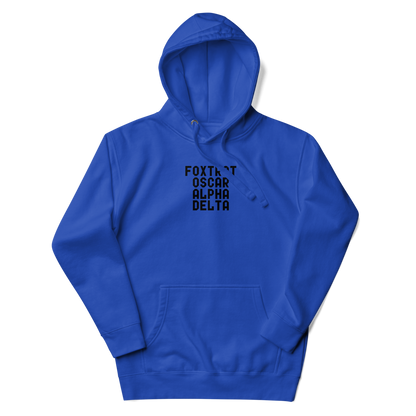 "Foxtrot Oscar Alpha Delta" printed on a team royal unisex hoodie laying on a flat surface with the hood up