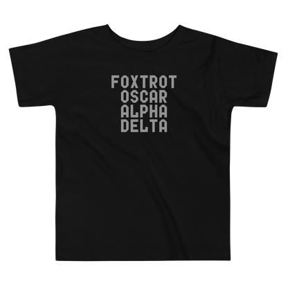 "Foxtrot Oscar Alpha Delta" printed on a black toddler short sleeve tee laying on a flat surface