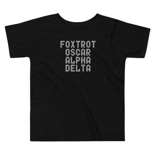 "Foxtrot Oscar Alpha Delta" printed on a black toddler short sleeve tee laying on a flat surface