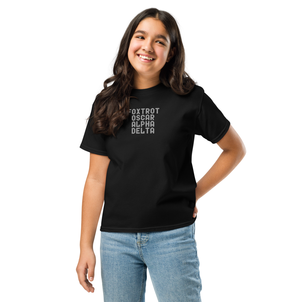 "Foxtrot Oscar Alpha Delta" printed on a black youth classic tee worn by a female