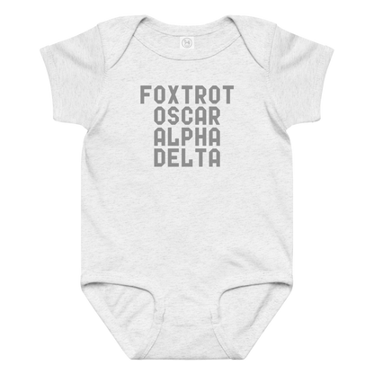"Foxtrot Oscar Alpha Delta" printed on a ash baby jersey bodysuit laying on a flat surface amongst other clothes