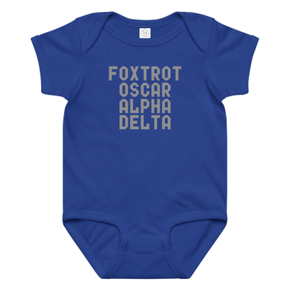 "Foxtrot Oscar Alpha Delta" printed on a royal baby jersey bodysuit laying on a flat surface amongst other clothes