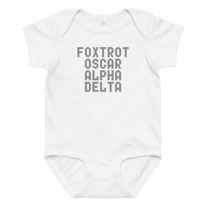 "Foxtrot Oscar Alpha Delta" printed on a white baby jersey bodysuit laying on a flat surface amongst other clothes