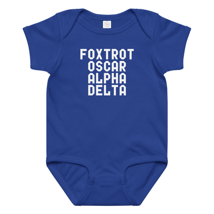 "Foxtrot Oscar Alpha Delta" printed on a royal baby jersey bodysuit laying on a flat surface amongst other clothes