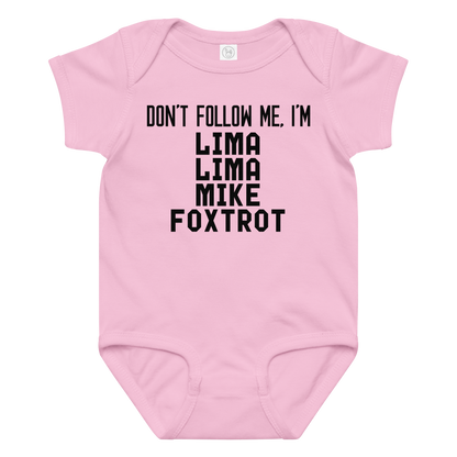 "Don’t follow me, I'm Lima Lima Mike Foxtrot" printed on a pink baby jersey bodysuit laying on a flat surface amongst other clothes
