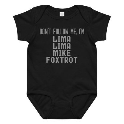 "Don’t follow me, I'm Lima Lima Mike Foxtrot" printed on a black baby jersey bodysuit laying on a flat surface amongst other clothes
