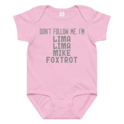 "Don’t follow me, I'm Lima Lima Mike Foxtrot" printed on a pink baby jersey bodysuit laying on a flat surface amongst other clothes