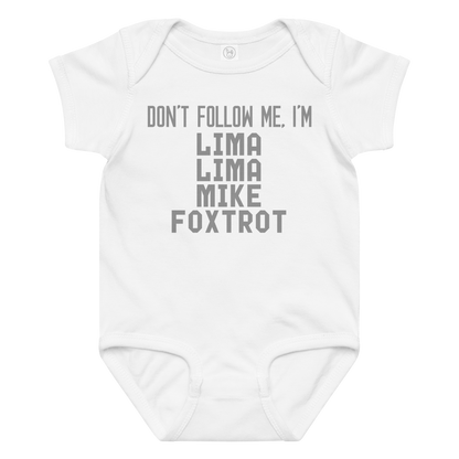 "Don’t follow me, I'm Lima Lima Mike Foxtrot" printed on a white baby jersey bodysuit laying on a flat surface amongst other clothes