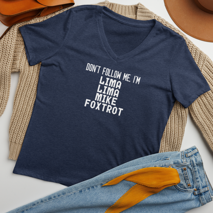 "Don’t follow me, I'm Lima Lima Mike Foxtrot" printed on a heather navy women's relaxed v-neck t-shirt laying on a flat surface amongst other clothes