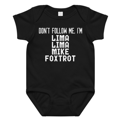 "Don’t follow me, I'm Lima Lima Mike Foxtrot" printed on a black baby jersey bodysuit laying on a flat surface amongst other clothes
