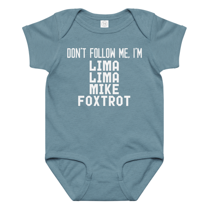 "Don’t follow me, I'm Lima Lima Mike Foxtrot" printed on a vintage indigo baby jersey bodysuit laying on a flat surface amongst other clothes