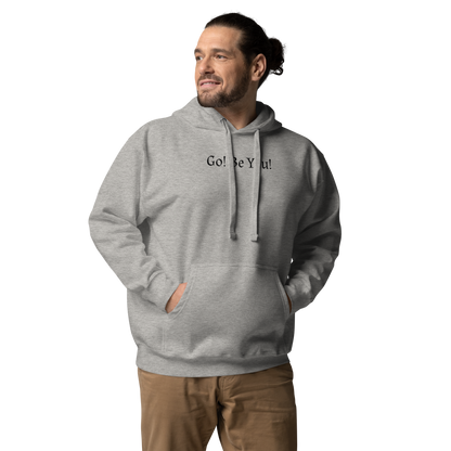 "Go! Be You!" printed on a carbon grey unisex hoodie worn by a male