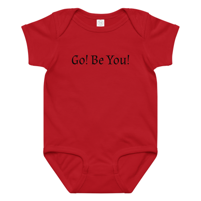 "Go! Be You!" printed on a red baby jersey bodysuit laying on a flat surface amongst other clothes
