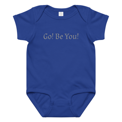 "Go! Be You!" printed on a royal baby jersey bodysuit laying on a flat surface amongst other clothes