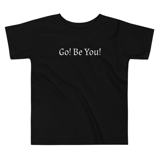 "Go! Be You!" printed on a black toddler short sleeve tee laying on a flat surface