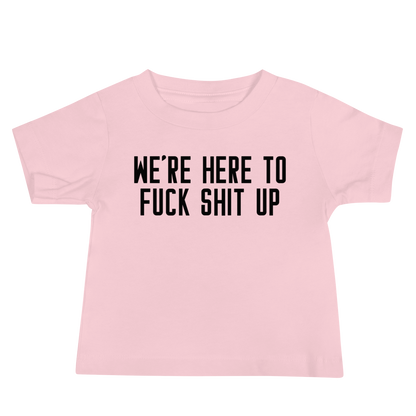 "We're Here To Fuck Shit Up" printed on a pink baby jersey short sleeve tee laying on a flat surface