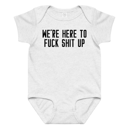 "We're Here To Fuck Shit Up" printed on a ash baby jersey bodysuit laying on a flat surface amongst other clothes