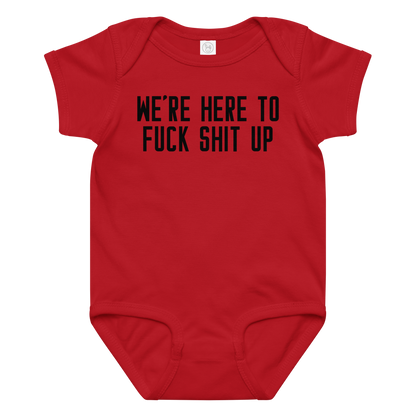 "We're Here To Fuck Shit Up" printed on a red baby jersey bodysuit laying on a flat surface amongst other clothes