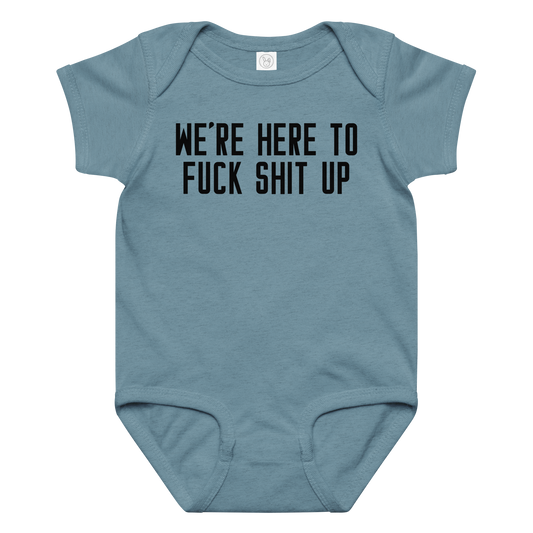 "We're Here To Fuck Shit Up" printed on a vintage indigo baby jersey bodysuit laying on a flat surface amongst other clothes
