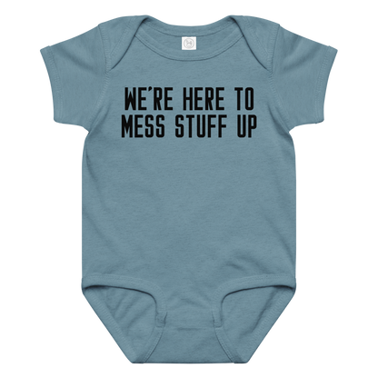 "We're Here To Mess Stuff Up" printed on a vintage indigo baby jersey bodysuit laying on a flat surface amongst other clothes
